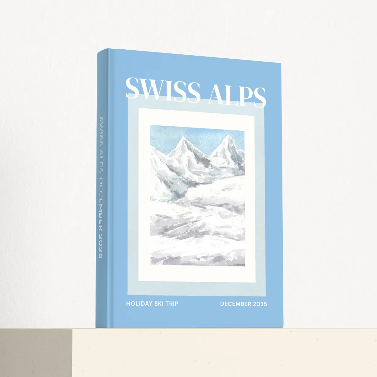 Swiss Alps travel photobook standing at an angle, showing the printed spine and matte hardcover